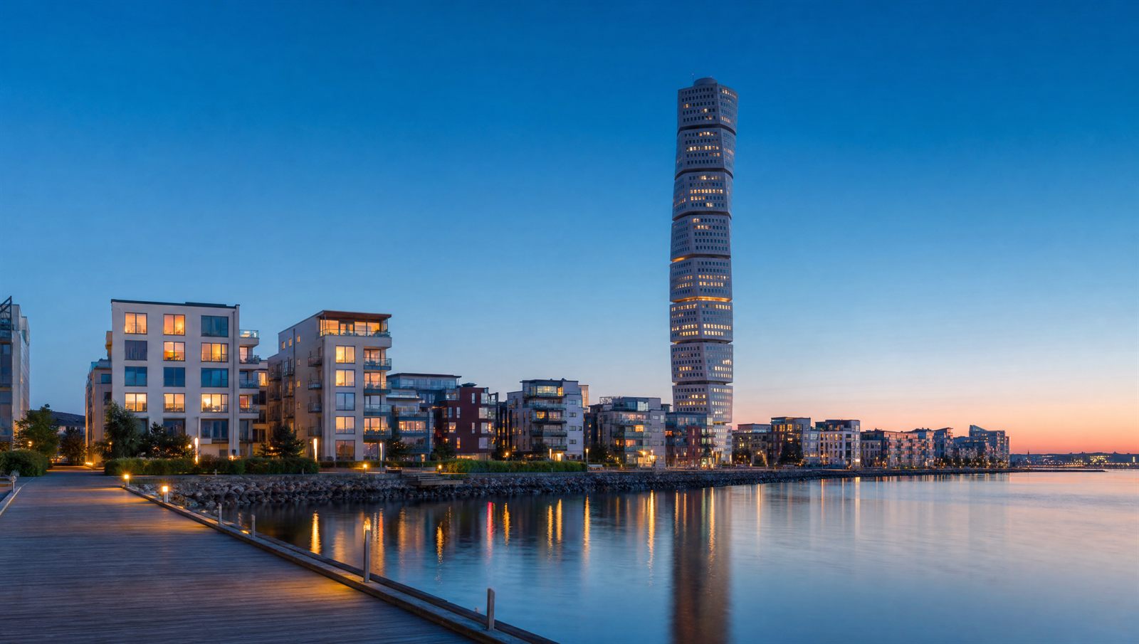 Västra hamnen i Malmö i blå timme med det vridna höghuset och promenaden längs Öresund