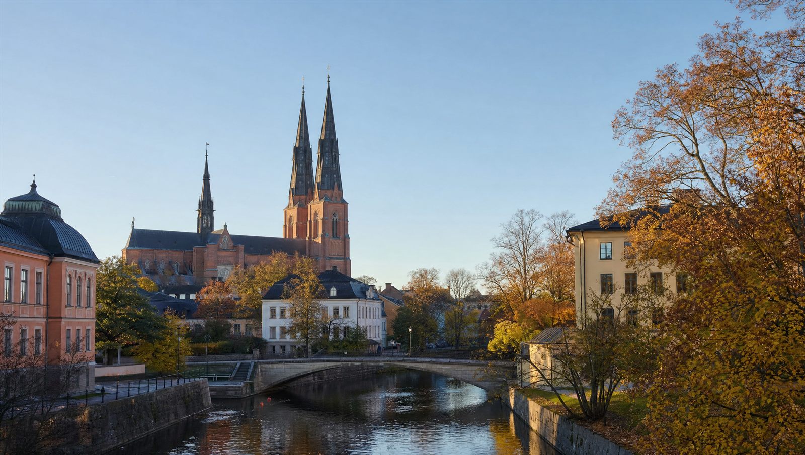 Uppsala domkyrkas två spiror över den låga stadskärnan och Fyrisån en höstdag